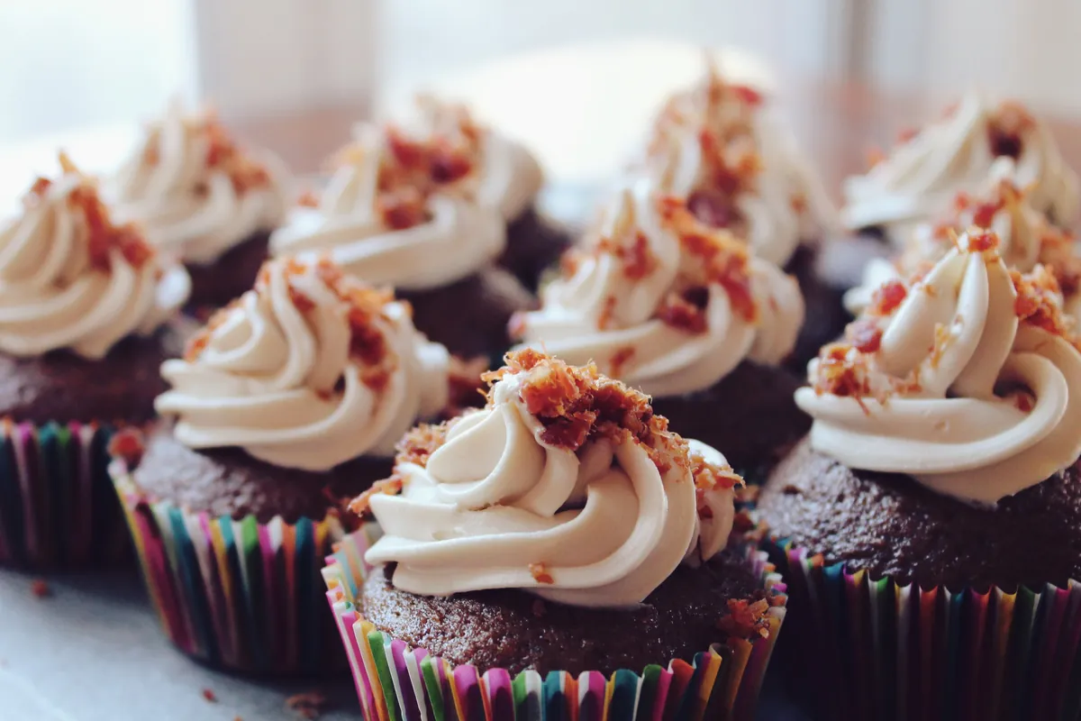 Cupcakes de chocolate con un remolino de crema blanca y virutas por encima